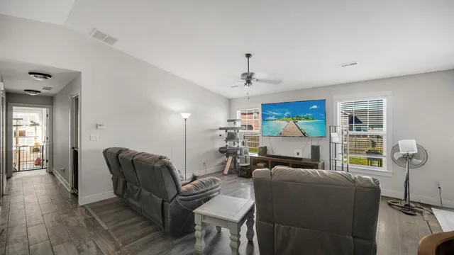 a living room with furniture and wooden floor