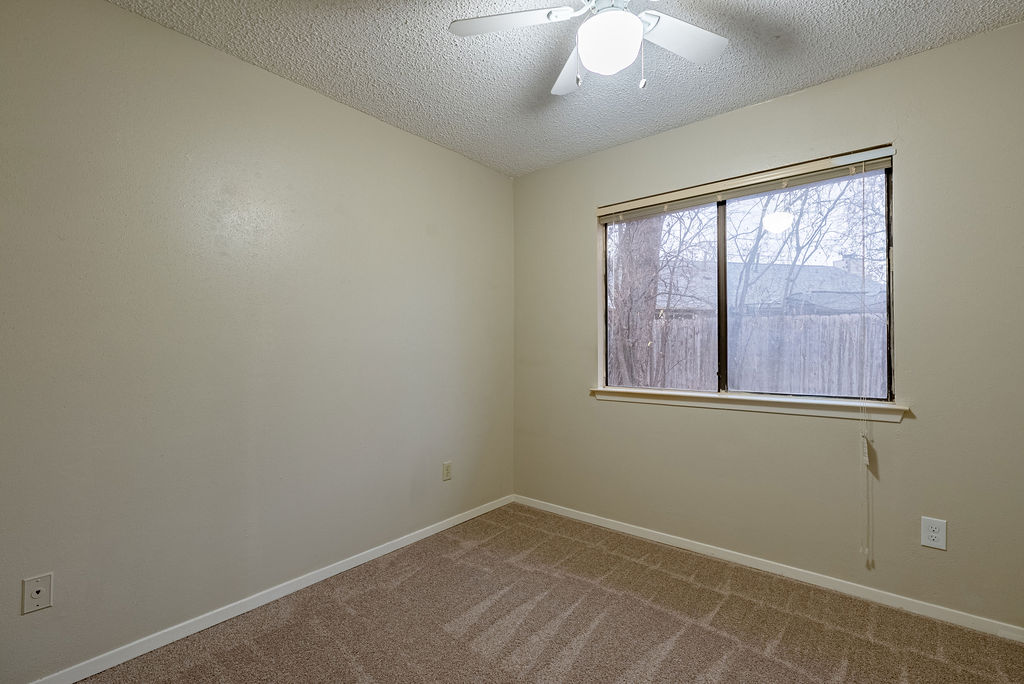 1205 Inland Greens, Unit B Austin, TX 78758 - Photo 12 of 16 Carpeted empty room featuring a textured ceiling and ceiling fan