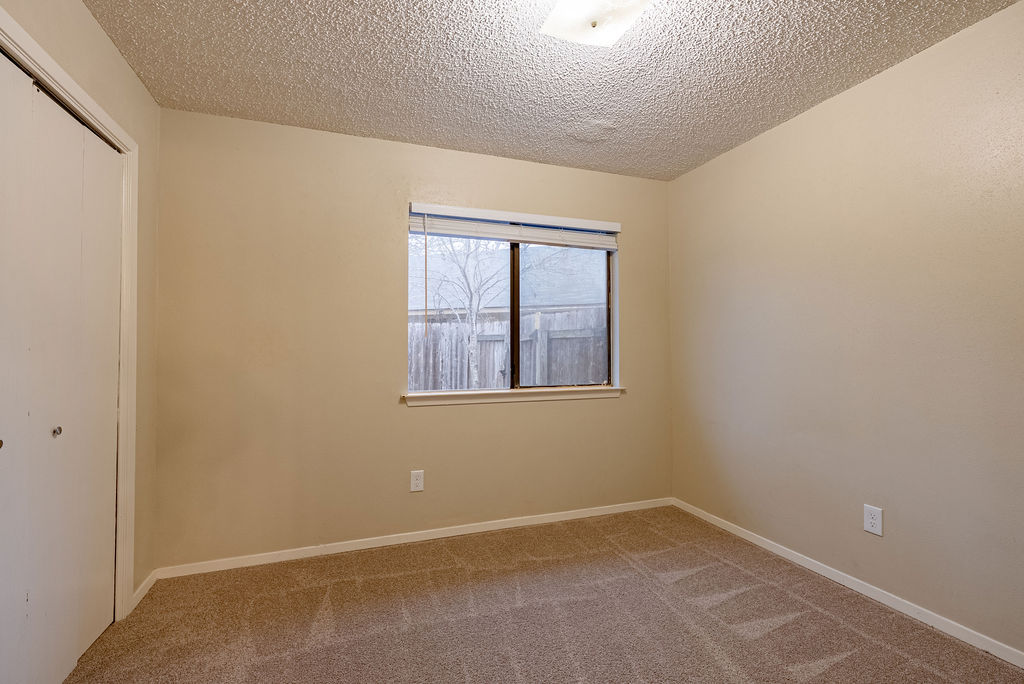 1205 Inland Greens, Unit B Austin, TX 78758 - Photo 9 of 16 Unfurnished bedroom featuring a closet, carpet floors, and a textured ceiling