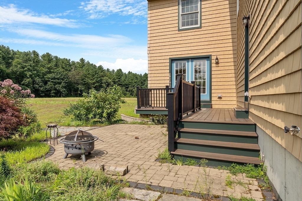 295 Pond Street Dunstable, MA 01827 - Photo 7 of 14 a view of a chair and tables in the backyard of the house