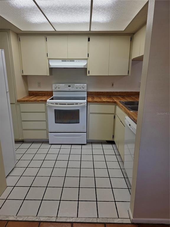 9000 Griggs Road, Unit G Englewood, FL 34224 - Photo 16 of 24 a kitchen with a stove and a refrigerator