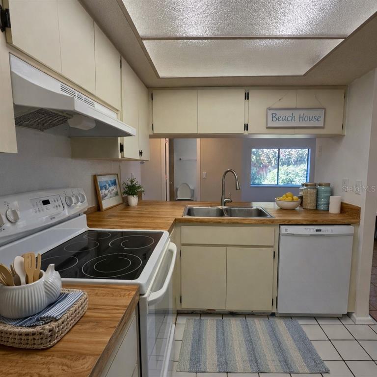 9000 Griggs Road, Unit G Englewood, FL 34224 - Photo 17 of 24 a kitchen with stainless steel appliances granite countertop a sink stove and cabinets