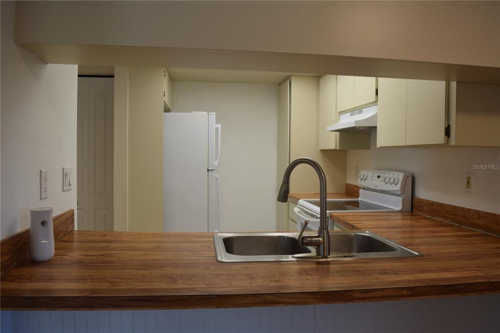 9000 Griggs Road, Unit G Englewood, FL 34224 - Photo 19 of 24 a kitchen with kitchen island a sink appliances and a counter top space