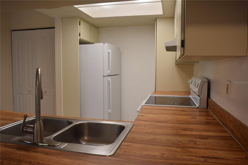 9000 Griggs Road, Unit G Englewood, FL 34224 - Photo 20 of 24 a view of a kitchen with refrigerator and wooden floor