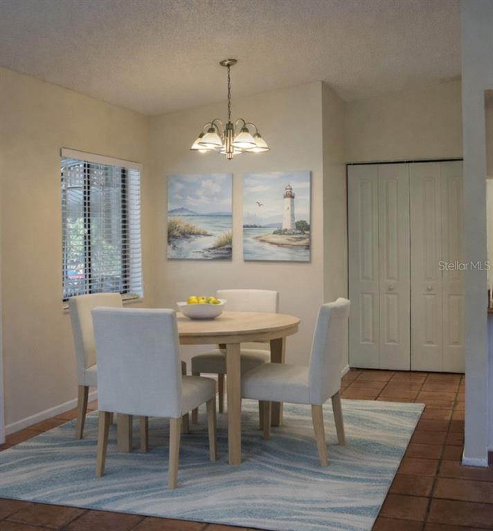 9000 Griggs Road, Unit G Englewood, FL 34224 - Photo 5 of 24 a view of a dining room with furniture window and wooden floor