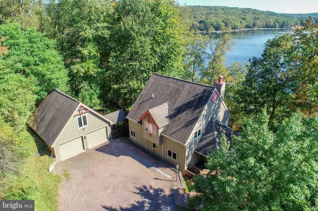 an aerial view of a house with a yard and a large tree