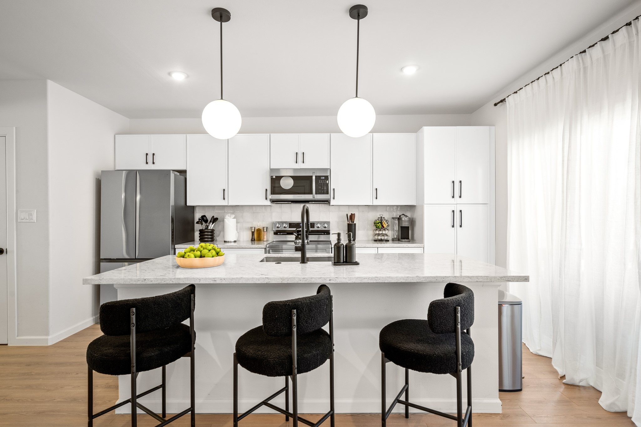 2413 Isabella Street Houston, TX 77004 - Photo 13 of 50 a kitchen with stainless steel appliances a refrigerator a stove a kitchen island a sink a stove a dining table and chairs with wooden floor