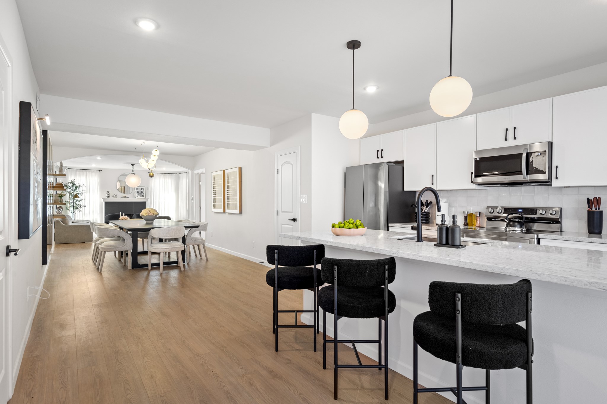2413 Isabella Street Houston, TX 77004 - Photo 14 of 50 a kitchen with stainless steel appliances a dining table chairs stove and white cabinets with wooden floor