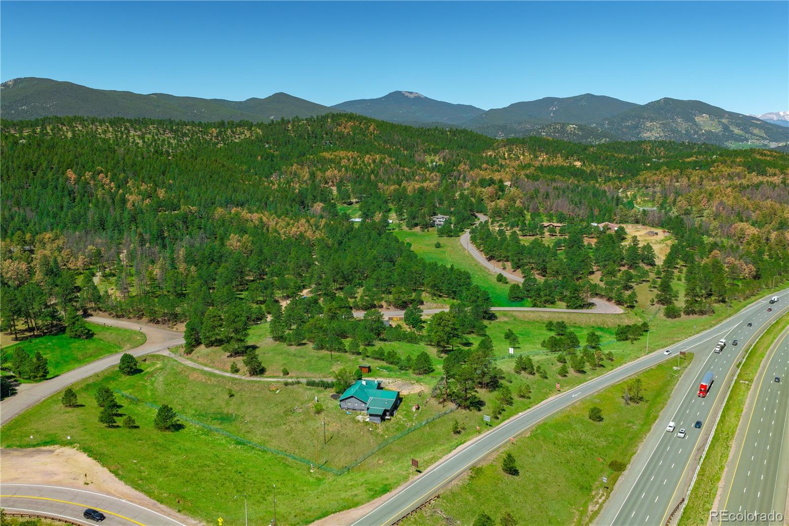 29793 Ruby Ranch Road Evergreen, CO 80439 - Photo 18 of 28 a view of a lush green field with a lake in the background