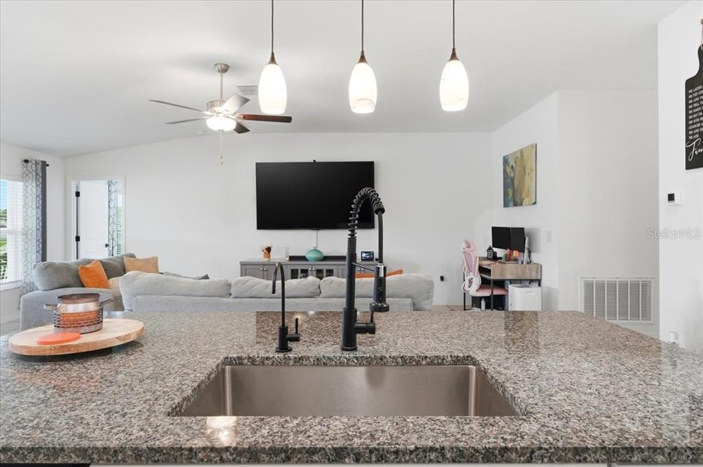1923 Red Loop Lakeland, FL 33801 - Photo 19 of 51 a kitchen with a faucet a sink and a living room area