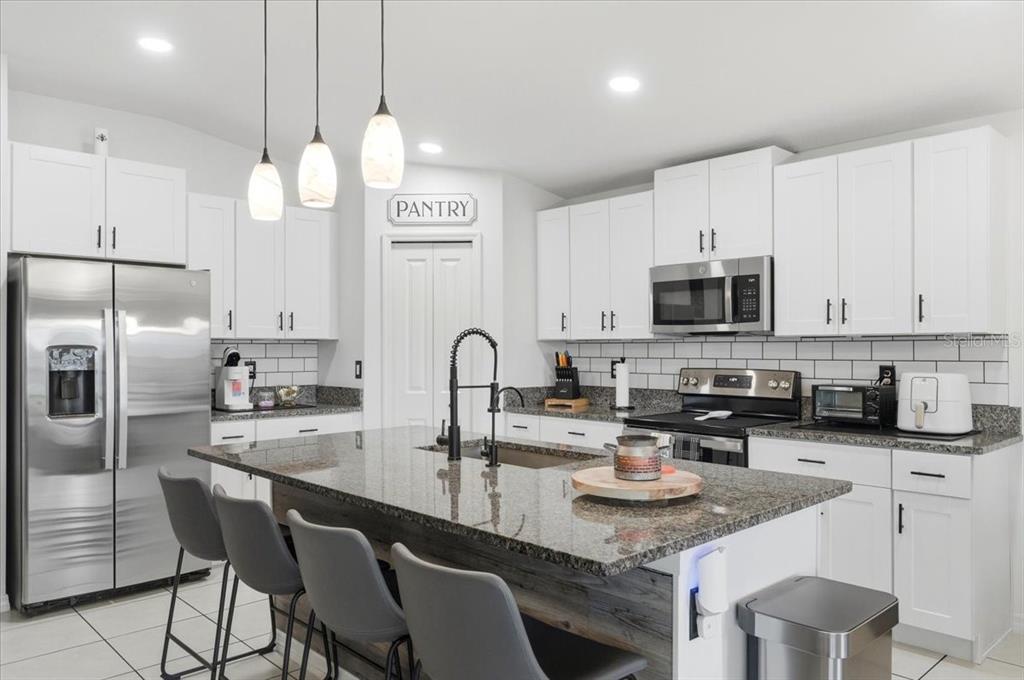 1923 Red Loop Lakeland, FL 33801 - Photo 20 of 51 a kitchen with stainless steel appliances granite countertop a sink a stove a refrigerator cabinets and chairs