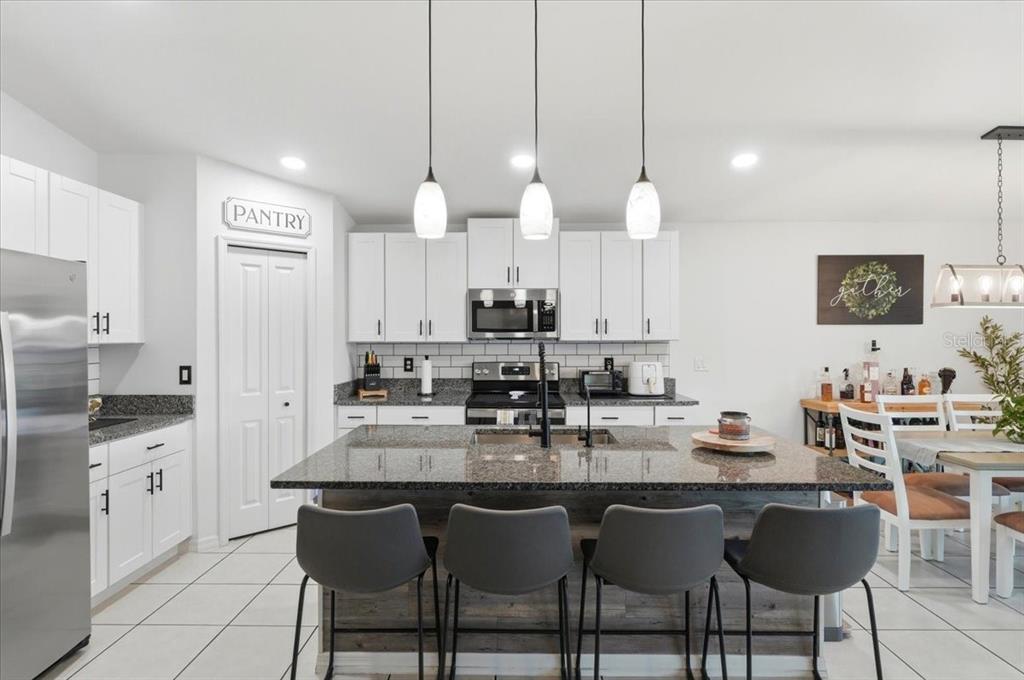 1923 Red Loop Lakeland, FL 33801 - Photo 21 of 51 a kitchen with granite countertop a table chairs stove and cabinets