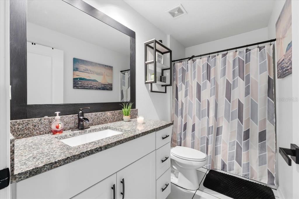 1923 Red Loop Lakeland, FL 33801 - Photo 31 of 51 a bathroom with a granite countertop sink mirror vanity and toilet