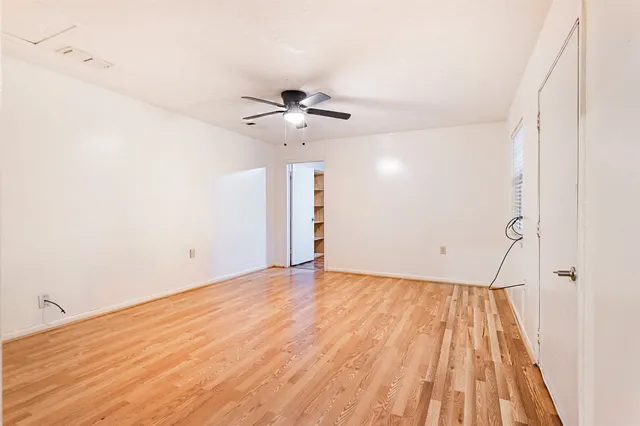 a view of an empty room with a ceiling fan