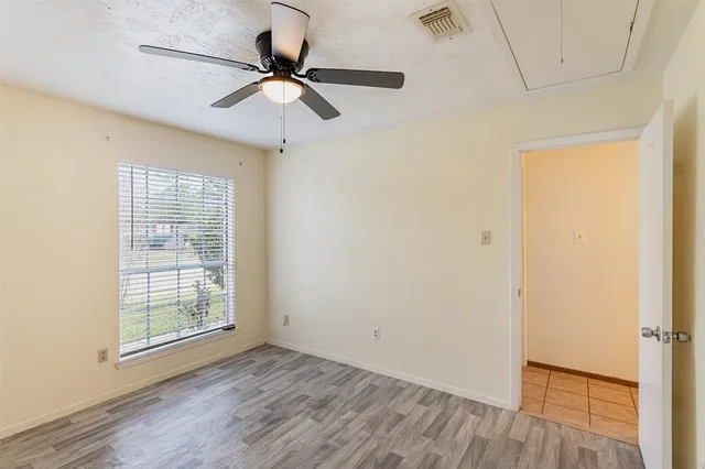 a view of room with hardwood floor and a ceiling fan