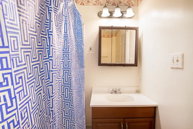 a bathroom with a sink a mirror and a window