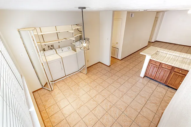 a view of a room with white walls washer and dryer