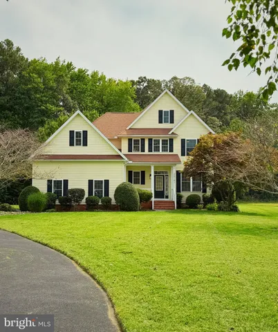 a view of a house with a big yard and large trees
