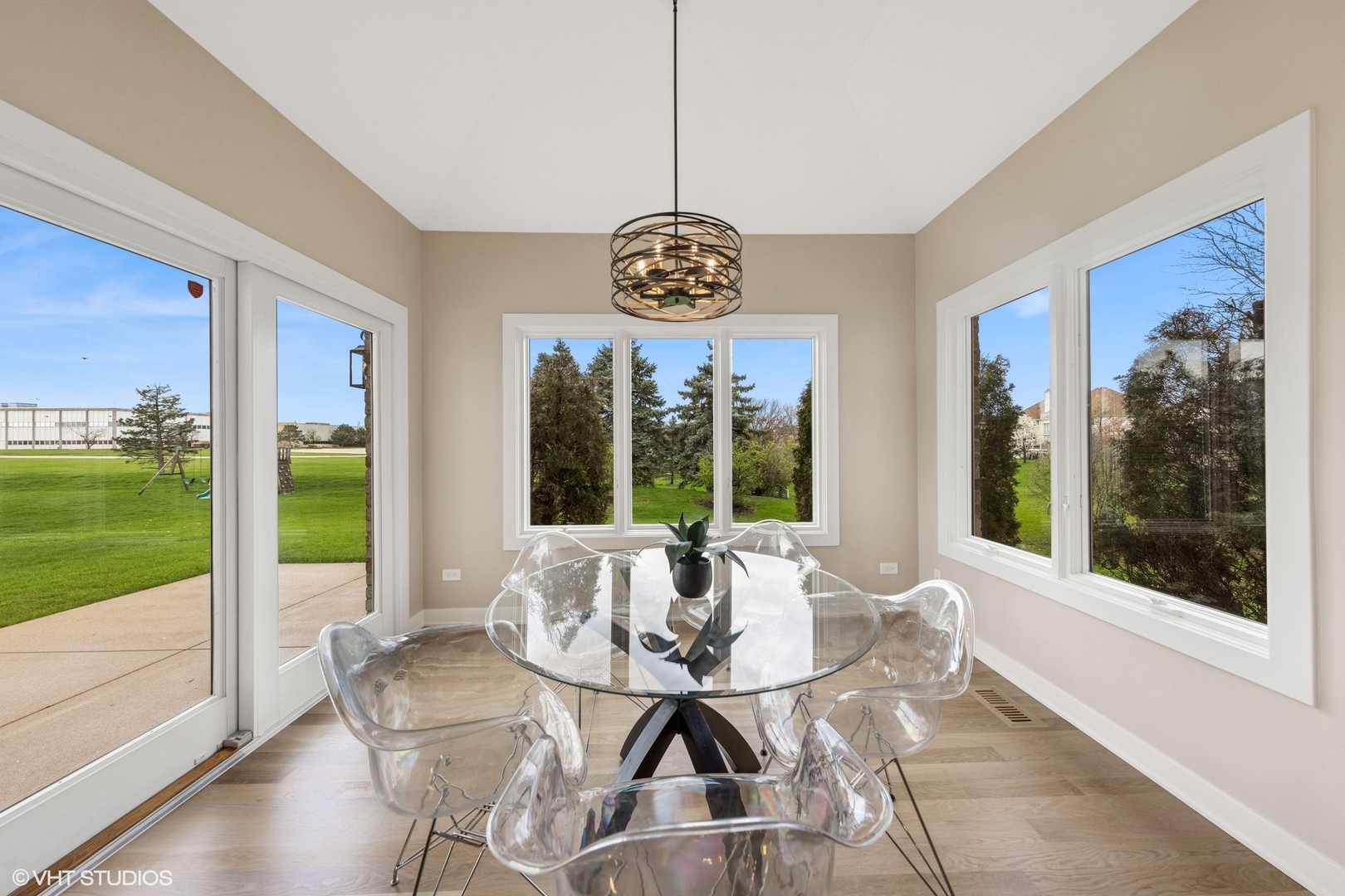 6878 Fieldstone Drive Burr Ridge, IL 60527 - Photo 13 of 45 a view of a dining room with furniture large windows and garden view