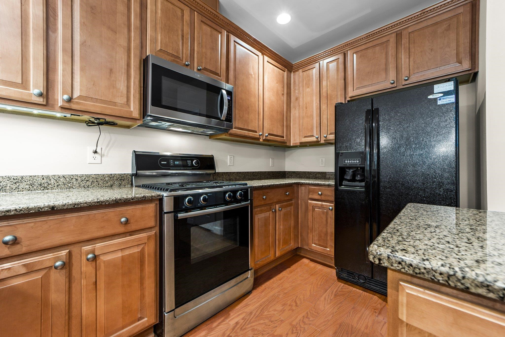 104 Harkness Circle Durham, NC 27705 - Photo 9 of 23 a kitchen with stainless steel appliances granite countertop a stove microwave and refrigerator