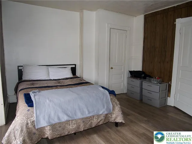 a bedroom with a bed and wooden floor