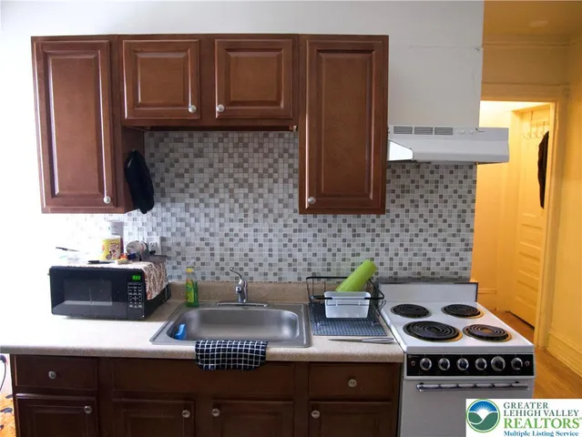 a kitchen with stainless steel appliances a sink dishwasher stove and cabinets