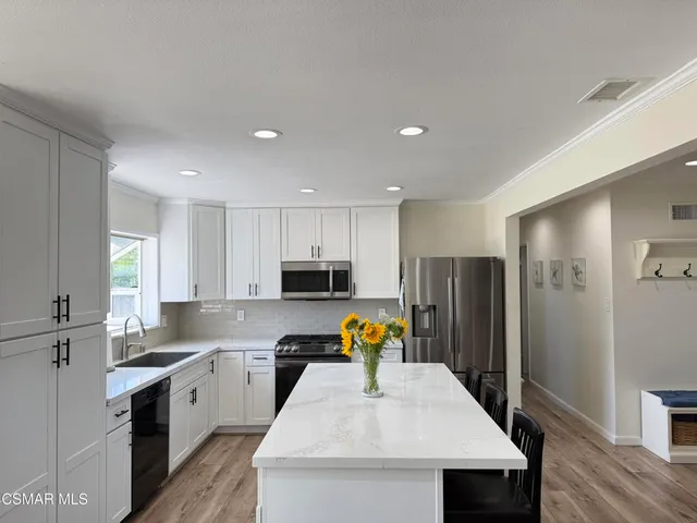 a kitchen with stainless steel appliances granite countertop a refrigerator sink and microwave
