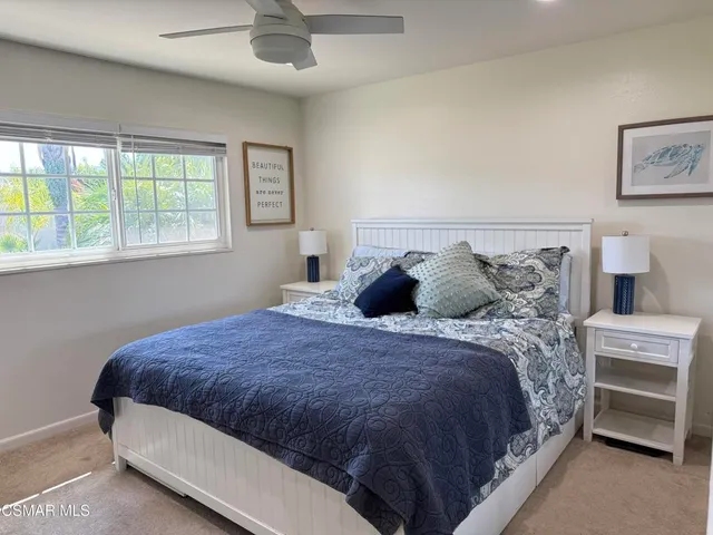a large bed sitting in a bedroom next to a window