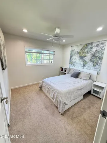 a bedroom with a bed and a large window