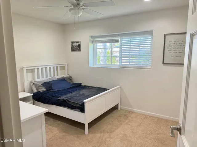 a bed sitting in a bedroom next to a window