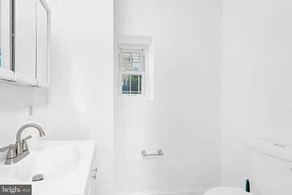 a bathroom with a sink a toilet and mirror