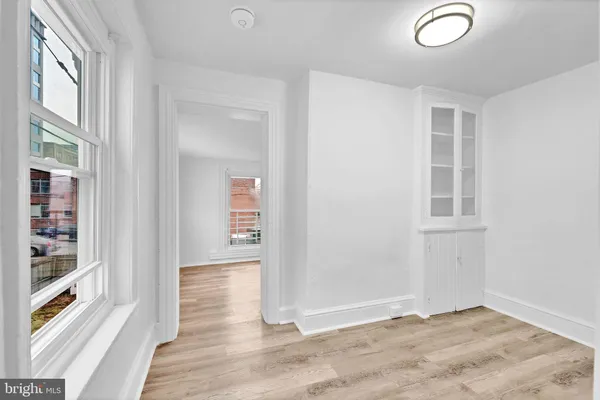 an empty room with wooden floor and windows