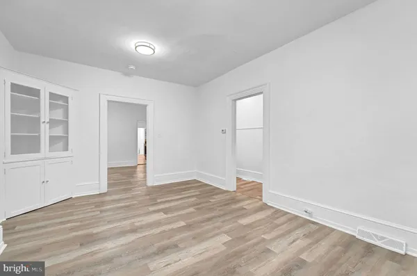 a view of an empty room with wooden floor and windows
