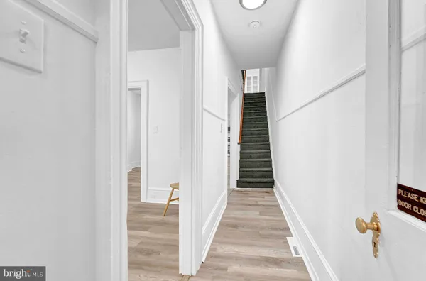a view of a hallway with wooden floor and staircase