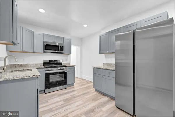 a kitchen with stainless steel appliances granite countertop a refrigerator stove and sink