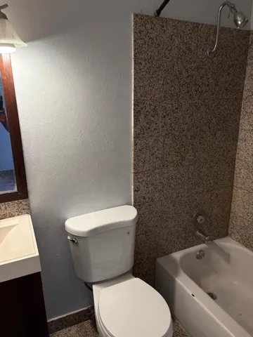 a white toilet sitting next to a bathroom sink