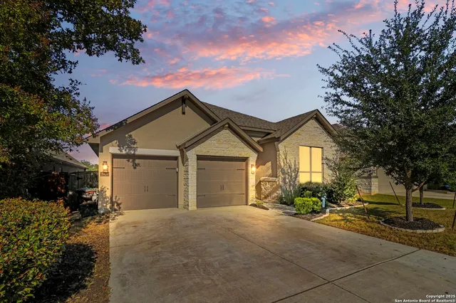 a view of a house with a yard and large tree