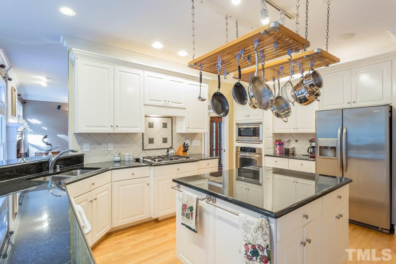 4625 Gamelyn Walk Raleigh, NC 27612 - Photo 7 of 25 a kitchen with stainless steel appliances granite countertop a sink a stove and a refrigerator