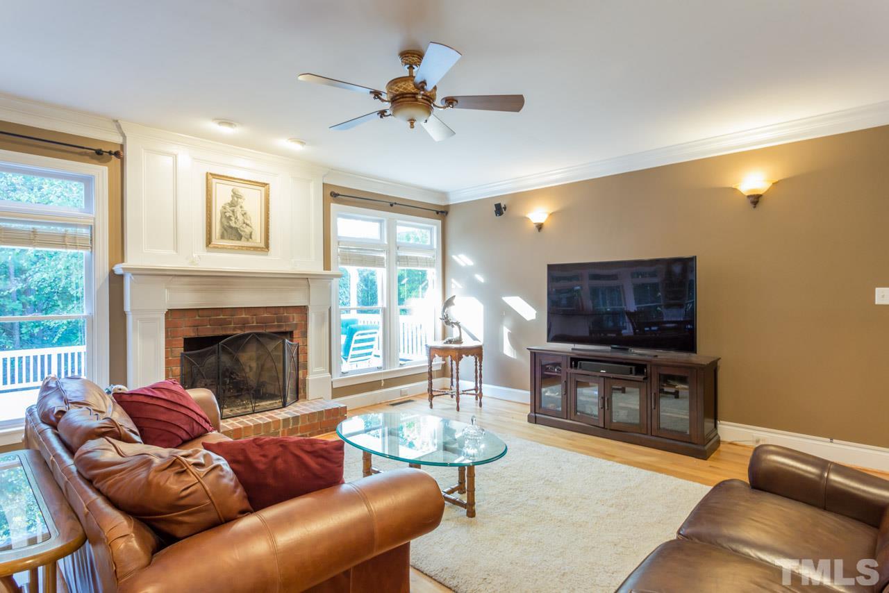 4625 Gamelyn Walk Raleigh, NC 27612 - Photo 9 of 25 a living room with furniture a fireplace and a flat screen tv