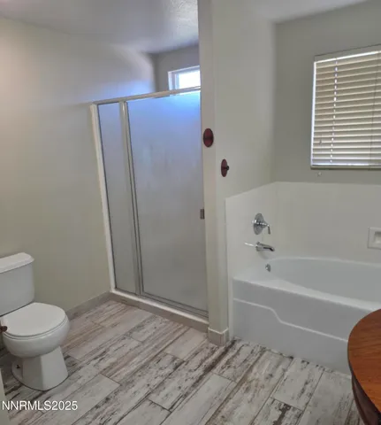 a bathroom with a toilet and a shower