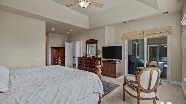 a bedroom with a bed and furniture with a flat tv screen