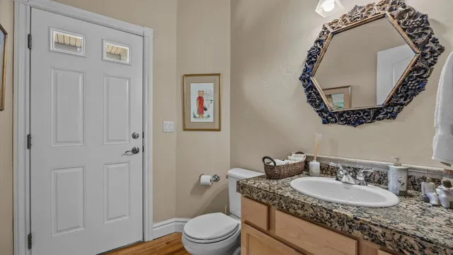 a bathroom with a granite countertop sink mirror vanity and toilet