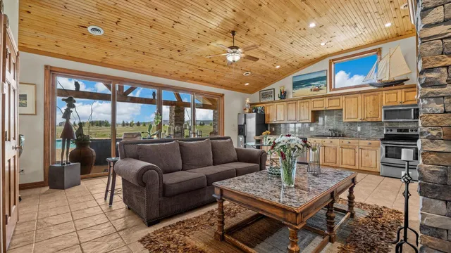 a living room with furniture a fireplace and a dining table with a kitchen view