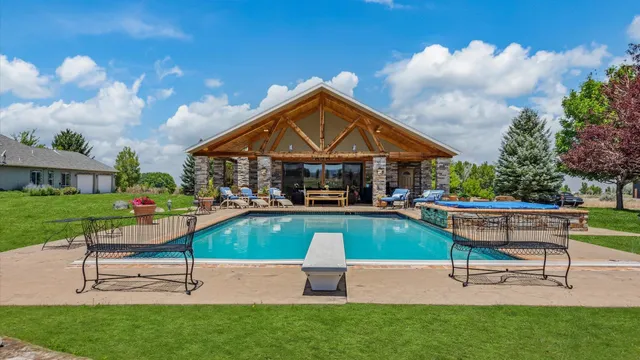 a view of pool with lawn chairs and a fire pit