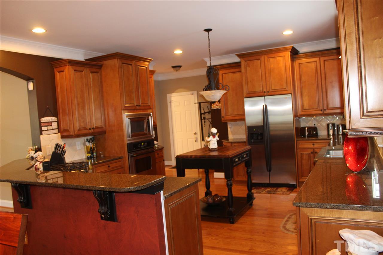 12336 Beestone Lane Raleigh, NC 27614 - Photo 10 of 21 a kitchen with stainless steel appliances kitchen island granite countertop a sink refrigerator and cabinets