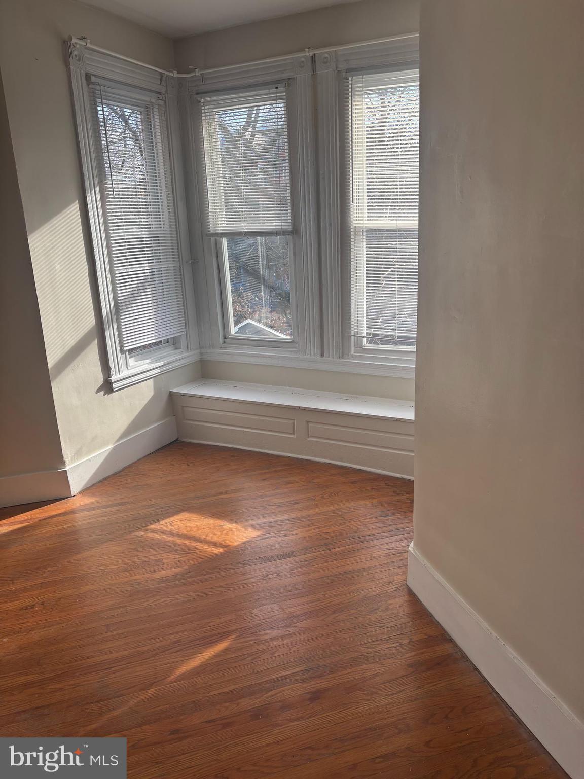 4715 Springfield Avenue, Unit 2F Philadelphia, PA 19143 - Photo 2 of 6 a view of an empty room with wooden floor and a window