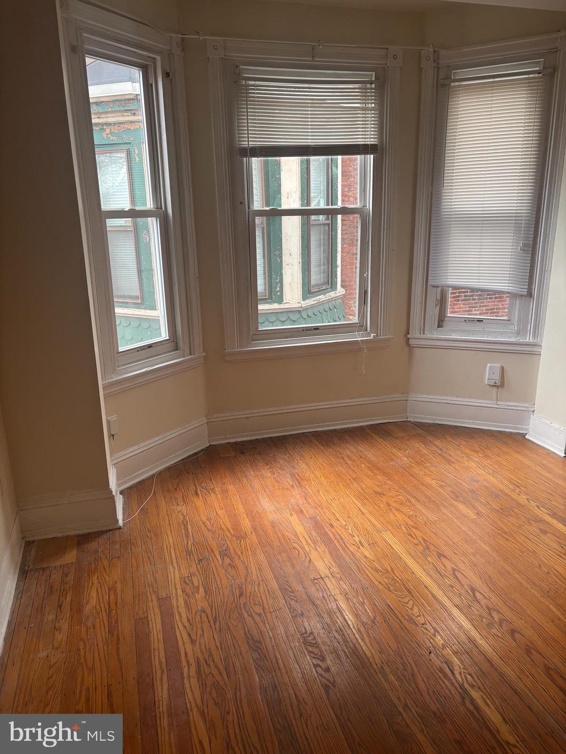 4715 Springfield Avenue, Unit 2F Philadelphia, PA 19143 - Photo 5 of 6 an empty room with wooden floor and windows