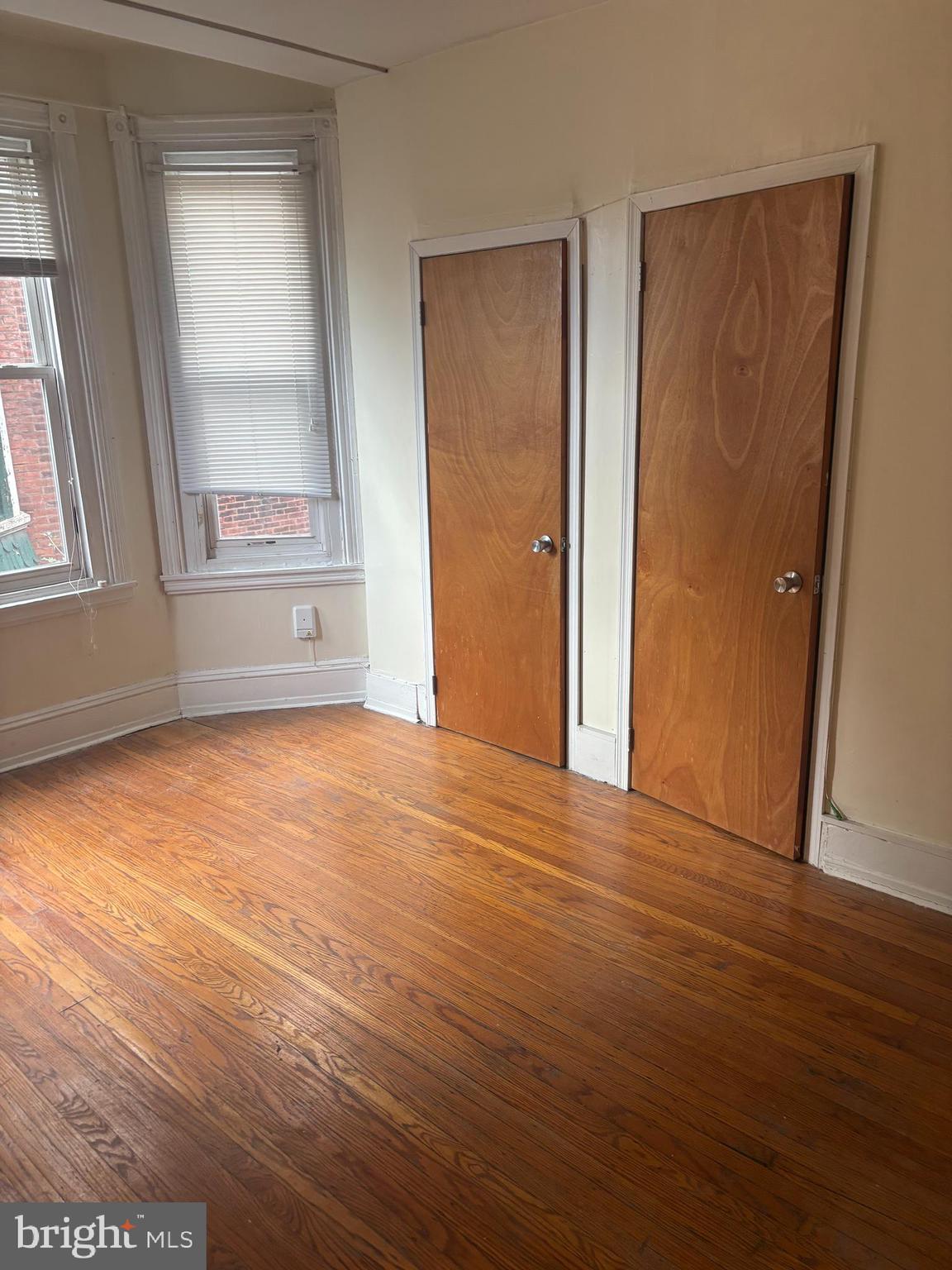 4715 Springfield Avenue, Unit 2F Philadelphia, PA 19143 - Photo 6 of 6 an empty room with wooden floor and windows