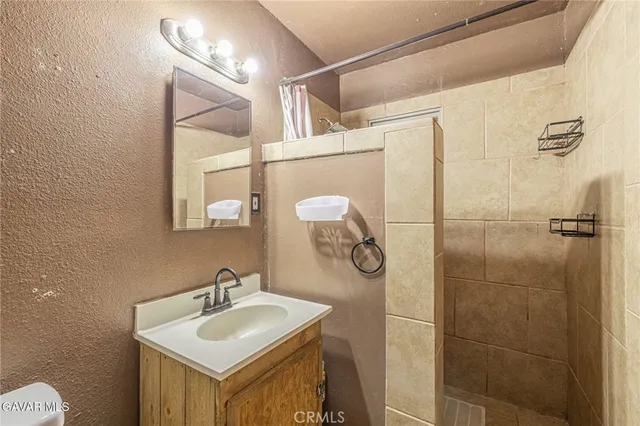 a bathroom with a sink mirror and shower