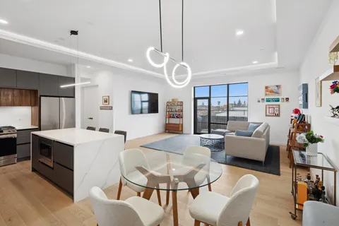 a living room with kitchen island furniture and a flat screen tv